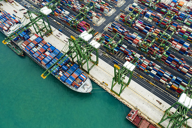 View from above, stunning aerial view of the port of Singapore with hundreds of colored containers ready to be loading on the cargo ships. The Port of Singapore is the second biggest port in the world.