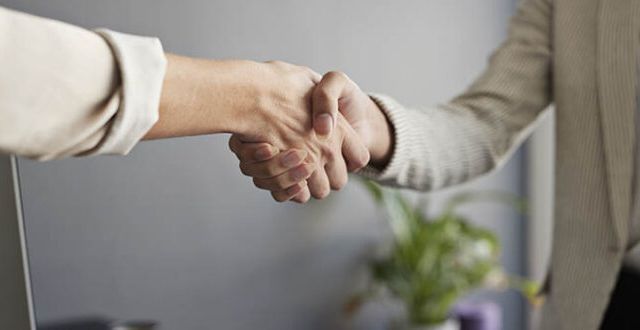 Female entrepreneurs shaking hands at workplace