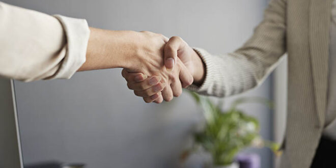 Female entrepreneurs shaking hands at workplace